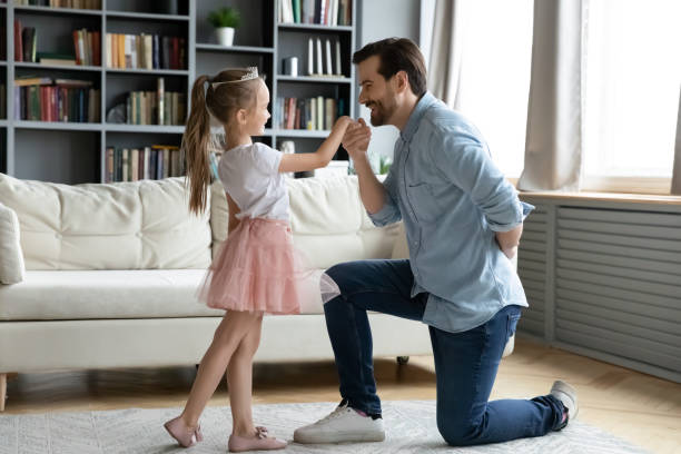 istock Young father standing on knee, inviting little daughter for dance. 1314393299