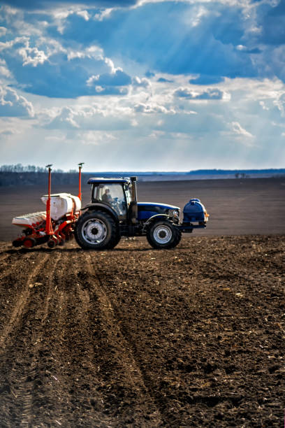 istock sowing work in the field. Tractor with seeder 1314393834