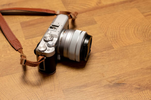 istock Old camera with leather strap on wooden table background 1314394007