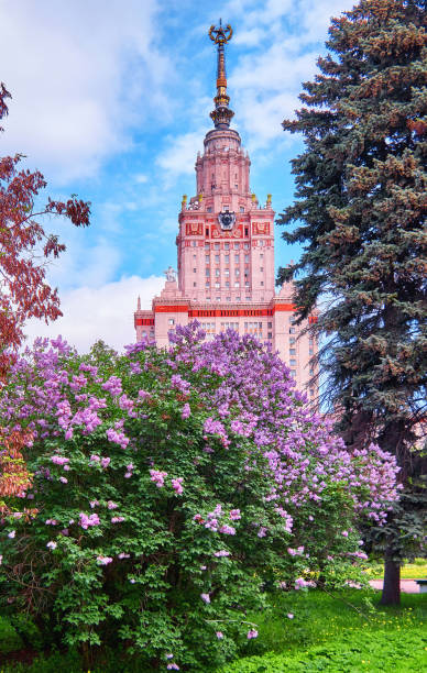 Sunny campus of Moscow university with blossoming trees under blue sky in springtime