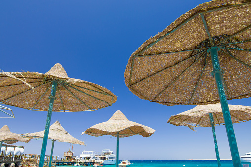 Egypt - Hurghada - The beach umbrellas and sun loungers at the famous resort on the Red Sea under a clear bright blue sky