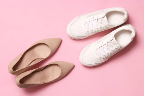 istock white sneakers and high heel shoes on a colored background top view. 1314402197
