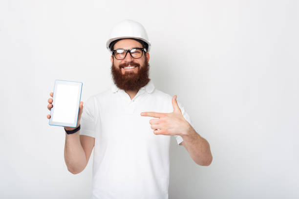 istock Young engineer dressed in white uniform is pointing at his tablet. 1314402235