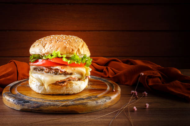 istock Delicious hamburger on wooden table, spices and brown fabric. 1314403225
