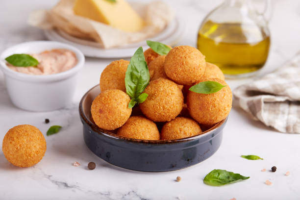 istock Deep fried Cheese balls. Freshly baked croquettes, served with basil leafs and sauce. 1314405470