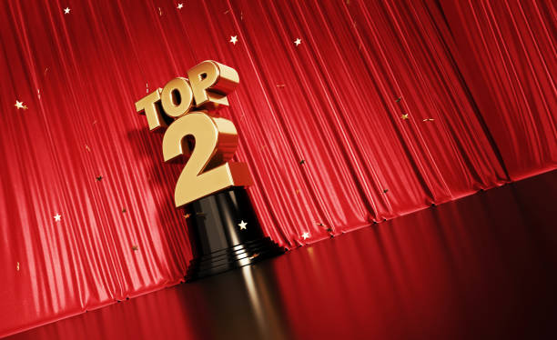istock Top 3 Concept - Gold Colored Confetti Falling Onto A Gold Top 2 Award Sitting Before Red Stage Curtain 1314405627