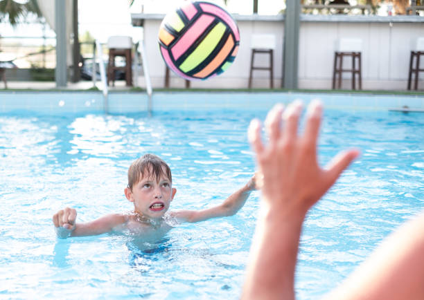 istock Small boy playing with ball in the pool 1314407770