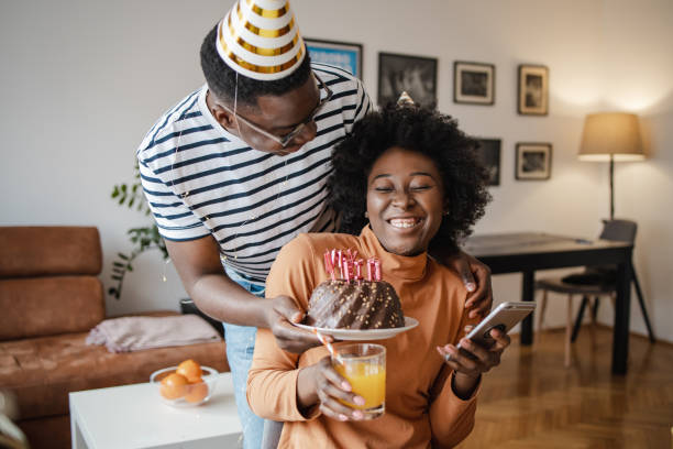 istock Young man surprising his girlfriend with a cake on her birthday 1314407833