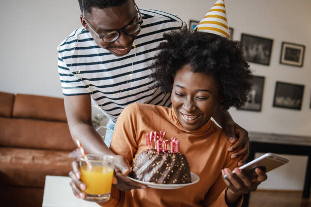 istock Young man surprising his girlfriend with a cake on her birthday 1314407839