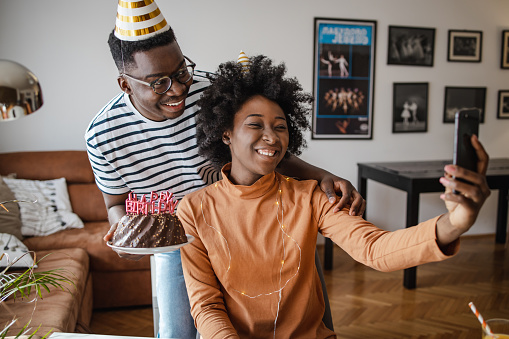 Couple talking on a video call on the smart phone and they are celebrating birthday during quarantine