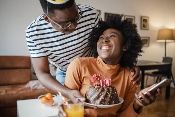 istock Young man surprising his girlfriend with a cake on her birthday 1314408443