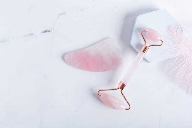 istock Trendy accessory facial massage gua sha roller on marble background 1314410203