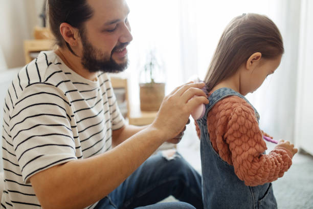 istock Responsible good father combing little daughters hair, preparations for school 1314410925