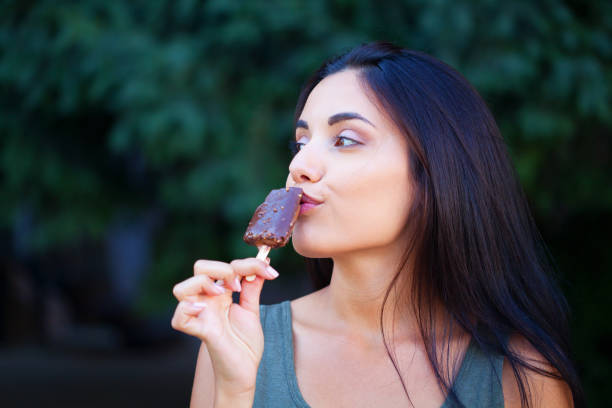 istock Beautiful woman eating ice-cream 1314412272