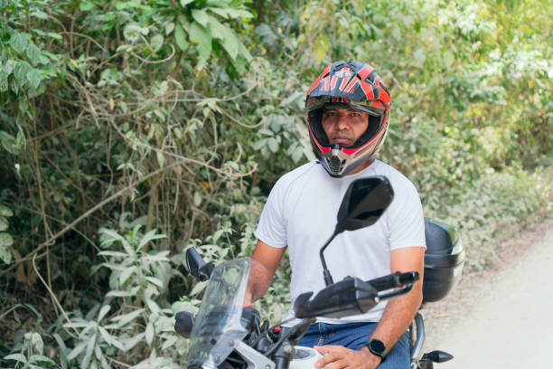istock Young man with his motorcycle parked on a country road 1314413030