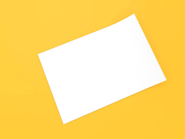 istock White sheet of A4 office paper on a yellow background. 1314414042