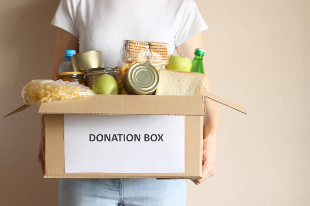 istock girl holding a box with donations 1314415125