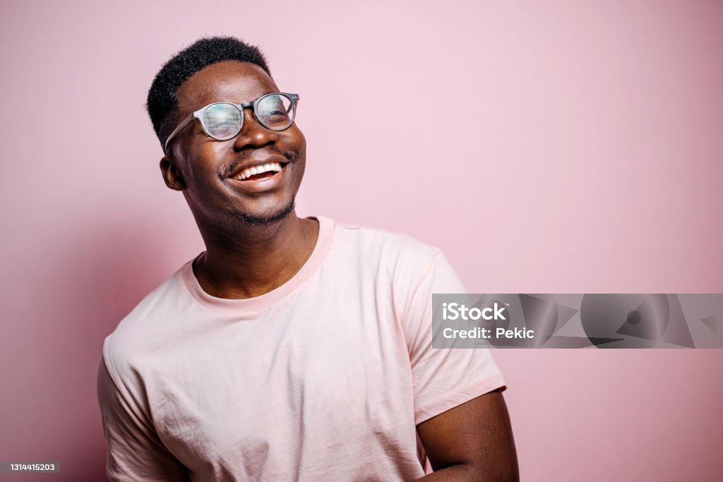 Always smile Portrait of handsome black man posing in front of pink background Men Stock Photo