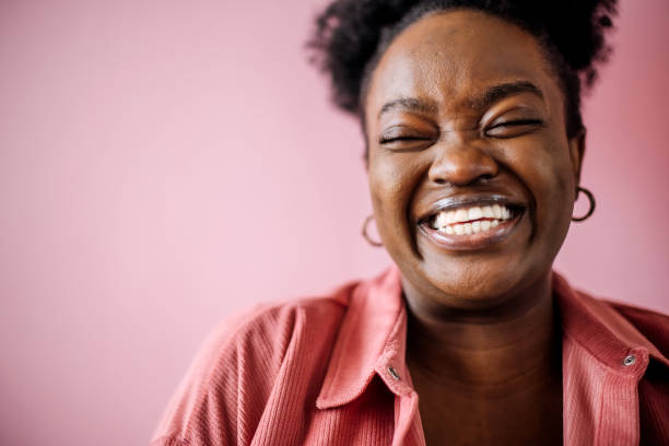 Young happy beautiful black woman posing in front of pink background Young happy beautiful black woman posing in front of pink background plus size photos stock pictures, royalty-free photos & images