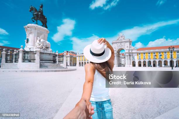 Tourist Woman In White Hat Holding Hand Of Her Boyfriend And Exploring Lisbon City Together Couple On Vacation Traveling Together Follow Me Commerce Square In Lisbon Portugal - Fotografias de stock e mais imagens de Viagem