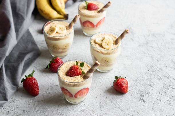 Magnolia dessert with fresh bananas and strawberries in glass cup, homemade milky dessert concept Magnolia dessert with fresh bananas and strawberries in glass cup, homemade milky dessert concept cake jar stock pictures, royalty-free photos & images