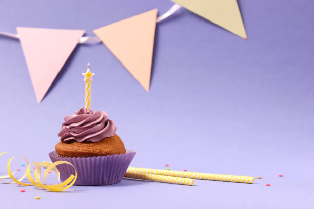 istock Delicious cupcake with a candle on a colored background with space for text. 1314417382
