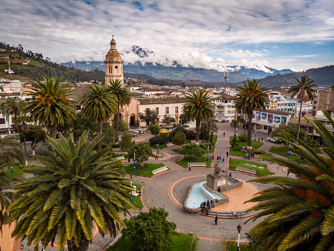 Simon Bolivar Square, Otavalo - Ecuador. June,15th2018. Behind there is the Cotacachi volcano. Many palm trees, big mountains and a cathedral can be appreciated. Illustrative image