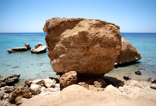 Rocks on beach, rocky coast Red Sea, blue sky and water, Sharm Al-Sheikh, Egypt