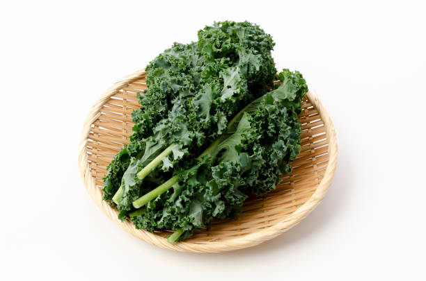 istock Fresh Curly green kale on bamboo sieve on white background 1314419674