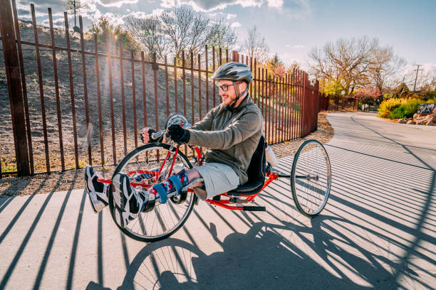 istock Handsome Young Man Riding a Red Handcycle Uphill Wearing Orthotic Leg Braces for Adaptive Exercise Outdoors in the Spring 1314422801