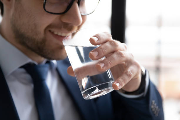 istock Smiling man drink pure mineral water from glass 1314422941