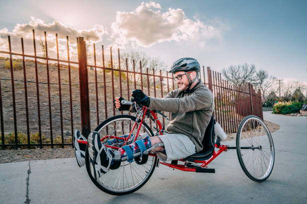 istock Handsome Young Man Having Fun Riding a Red Handcycle Wearing Orthotic Leg Braces for Adaptive Exercise Outdoors in the Spring 1314422979