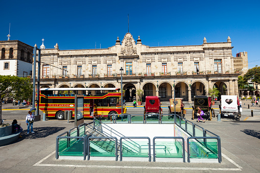 Guadalajara, Jalisco, Mexico - January 20, 2020: The Municipal Palace in Plaza Guadalajara in downtown Guadalajara, Jalisco, Mexico with tourist buses and .