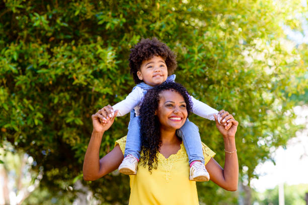 istock Daughter on mother's shoulder strolling in the park 1314428901