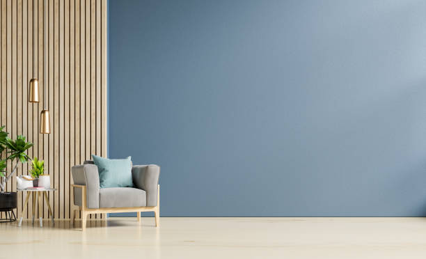 スタイリッシュなモダンな木製リビングルームには、空のダークブルーの壁の背景にアームチェアがあります。