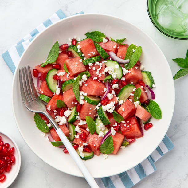 Watermelon, cucumber, feta and mint salad in white bowl stock photo