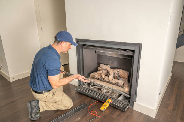 Technician working on a gas fireplace Service technician repairing a gas fireplace in a home fireplace stock pictures, royalty-free photos & images