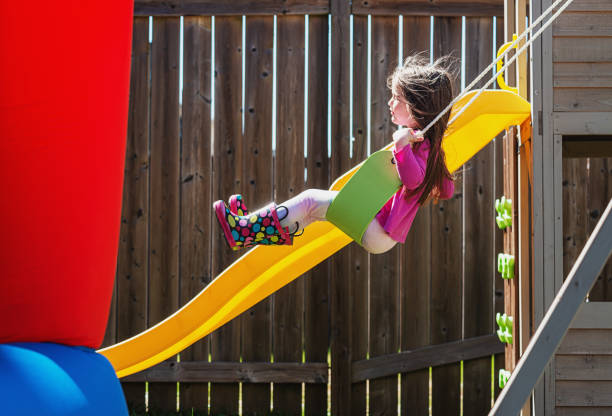 istock Girl Enjoys Swinging on Her Backyard Playground 1314435141