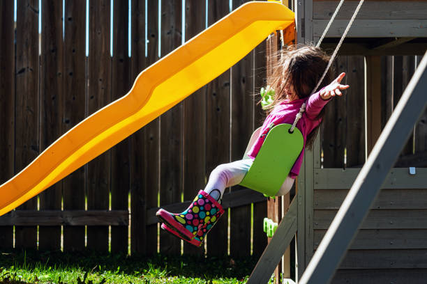 istock Girl Enjoys Swinging on Her Backyard Playground 1314435142