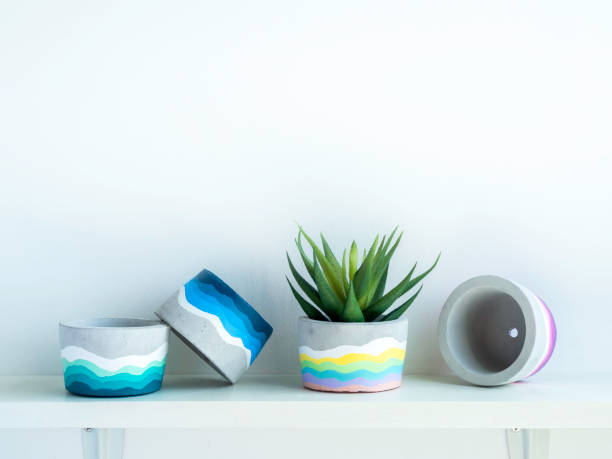 istock Colorful DIY concrete pot on wooden shelf. 1314435739