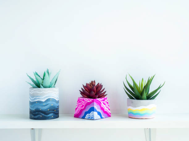 istock Colorful DIY concrete pot on wooden shelf. 1314435747