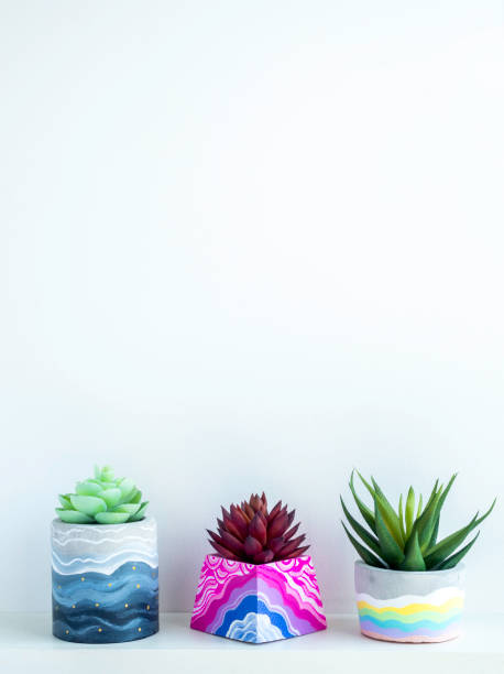 istock Colorful DIY concrete pot on wooden shelf. 1314435751