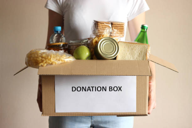 istock girl holding a box with donations 1314436025