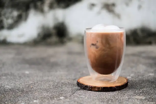 Photo of Iced Mocha coffee in double wall glass on a dirty background