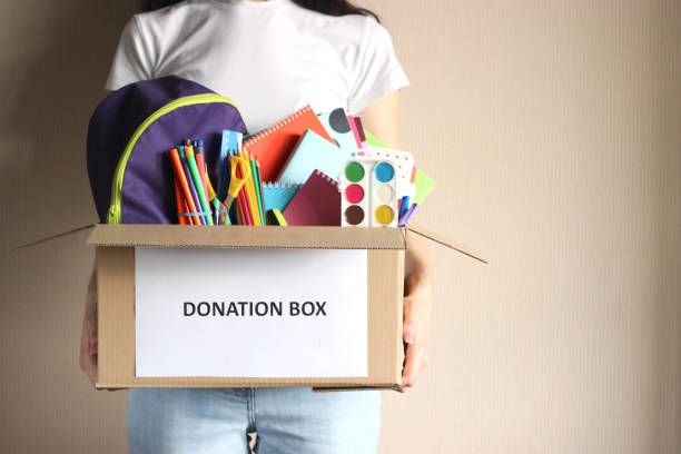 istock girl holding a box with donations 1314439651