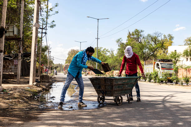 road sweeper worker cleaning the road in delhi during lock down to fight the spread of the COVID-19 corona virus.