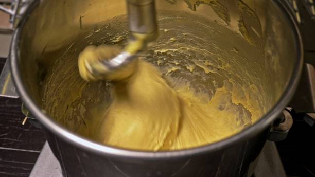 istock Mixing dough for bread baking with professional kneader spiral machine at the manufacturing. The dough is kneaded for burgers. 1314444717
