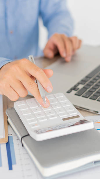 istock Close-up business people using a calculator to write notes with calculations, graph analysis on financial accounting concepts. 1314446605