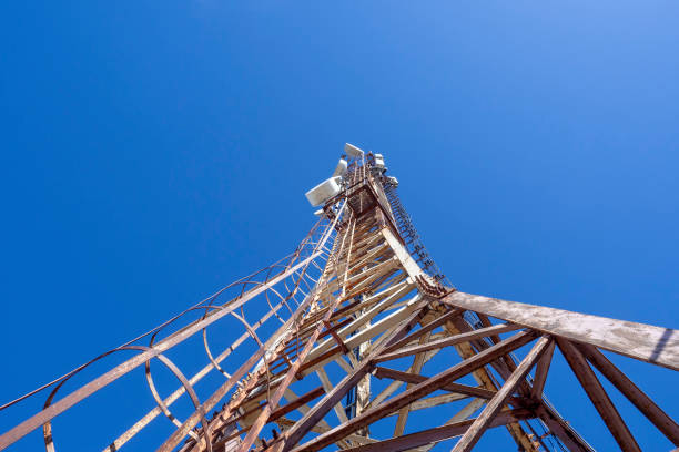 istock Mobile communications repeater tower, digital television. Metal tower against the blue sky, bottom view. 1314452342