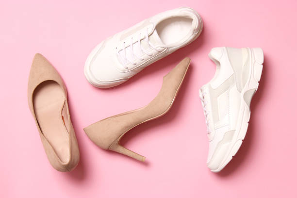 istock white sneakers and high heel shoes on a colored background top view. 1314456384